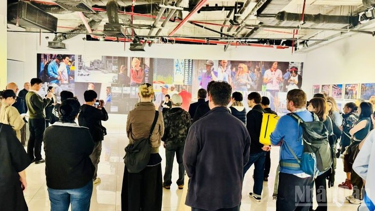 Les participants écoutent attentivement la présentation de l’exposition. Photo: nhandan.vn